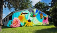 Rendering of proposed mural with birds, a butterfly, and flowers, set to a blue and green background